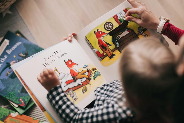 Kind liest ein Kinderbuch mit Eltern